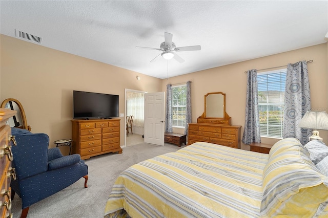 bedroom with ceiling fan, carpet, and a textured ceiling