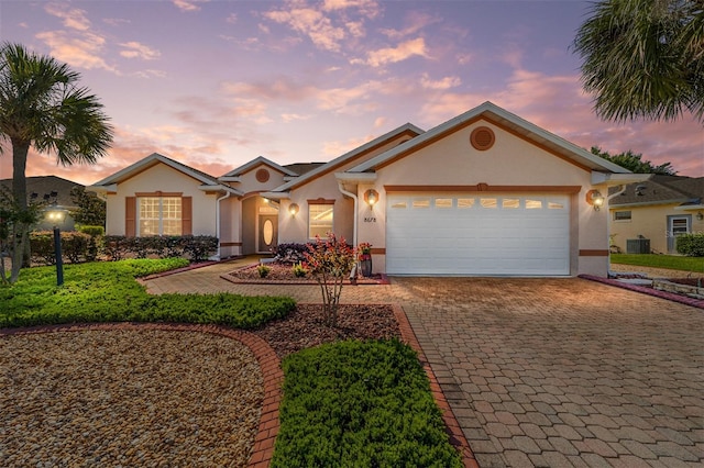 view of front of house featuring a garage and central AC unit