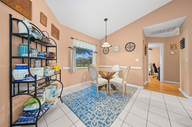 dining room featuring tile patterned floors and lofted ceiling