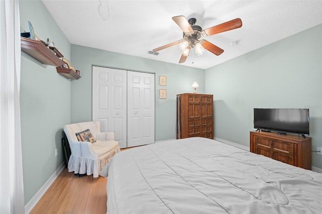 bedroom featuring ceiling fan, a closet, and light hardwood / wood-style flooring