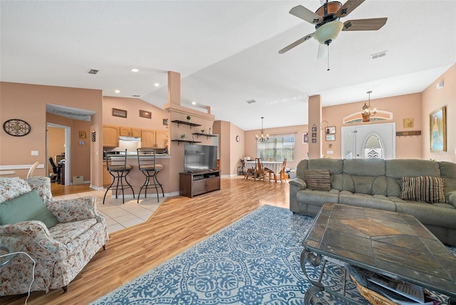 living room with ceiling fan with notable chandelier, light wood-type flooring, and lofted ceiling