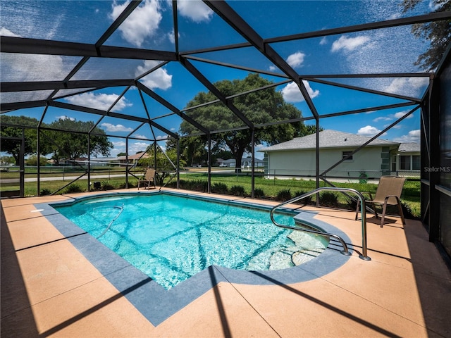 view of swimming pool featuring glass enclosure and a patio area