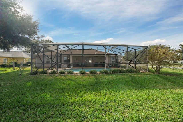 back of house featuring glass enclosure and a yard