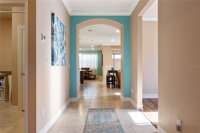 hall with crown molding and light tile floors