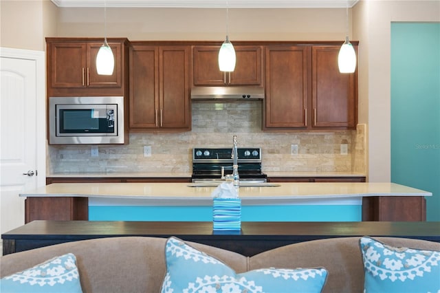 kitchen featuring a kitchen island with sink, hanging light fixtures, crown molding, backsplash, and stainless steel appliances