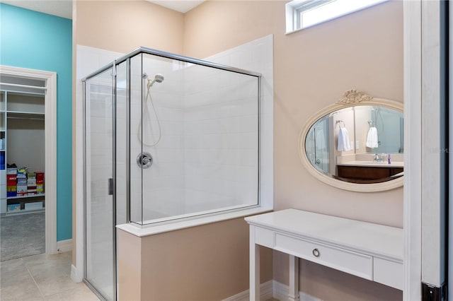 bathroom with walk in shower, vanity with extensive cabinet space, and tile floors