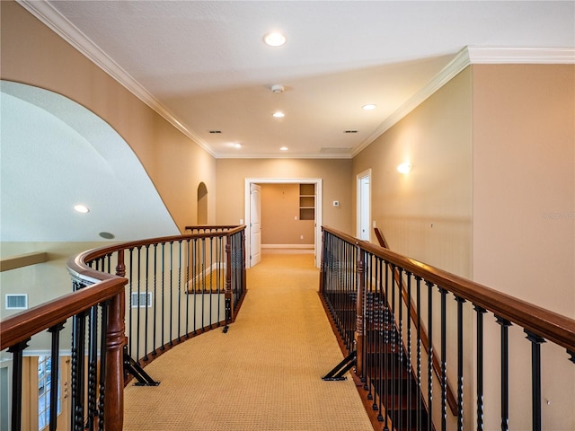 hall with crown molding and light colored carpet