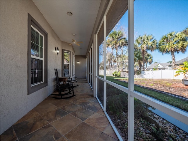 unfurnished sunroom featuring ceiling fan