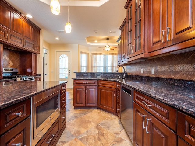 kitchen with stainless steel appliances, decorative backsplash, sink, and pendant lighting