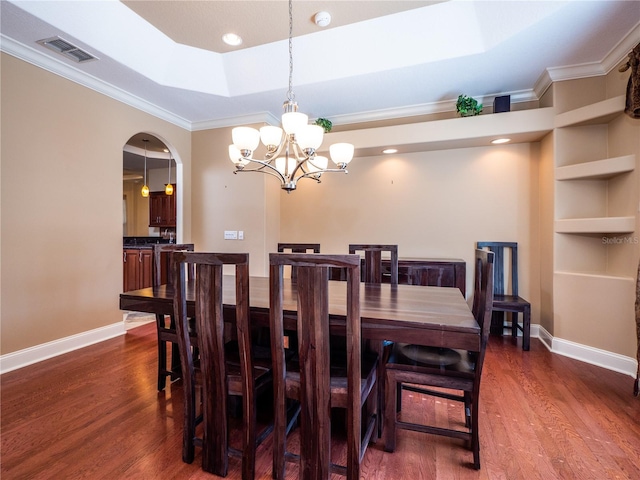 dining room with a notable chandelier, crown molding, a raised ceiling, and dark hardwood / wood-style flooring