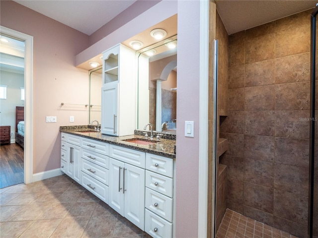 bathroom featuring vanity, tile patterned floors, and tiled shower