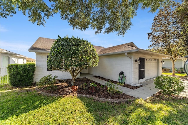 view of front of house featuring a garage and a front lawn