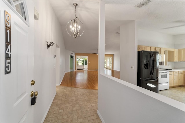 hallway with light hardwood / wood-style floors and an inviting chandelier