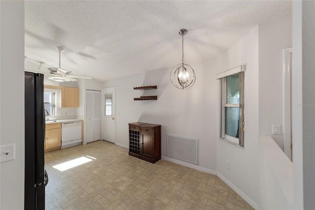 kitchen with black refrigerator, pendant lighting, ceiling fan with notable chandelier, light brown cabinets, and dishwasher