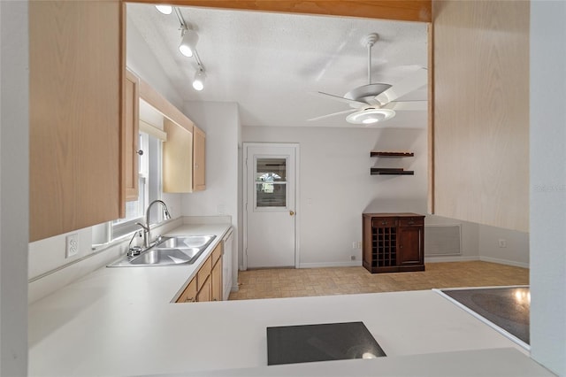 kitchen with a textured ceiling, light brown cabinets, ceiling fan, and sink