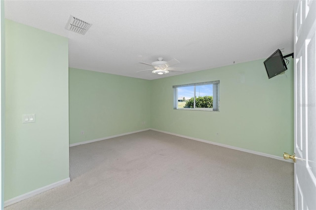 carpeted empty room featuring ceiling fan and a textured ceiling