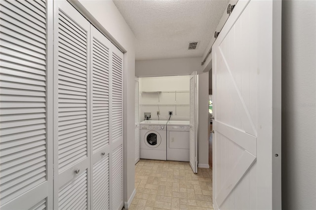 clothes washing area featuring light tile floors, a textured ceiling, washing machine and clothes dryer, washer hookup, and hookup for an electric dryer