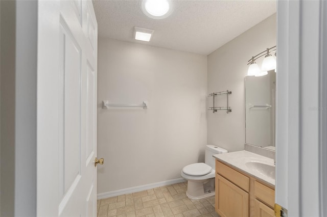 bathroom featuring oversized vanity, toilet, tile flooring, and a textured ceiling