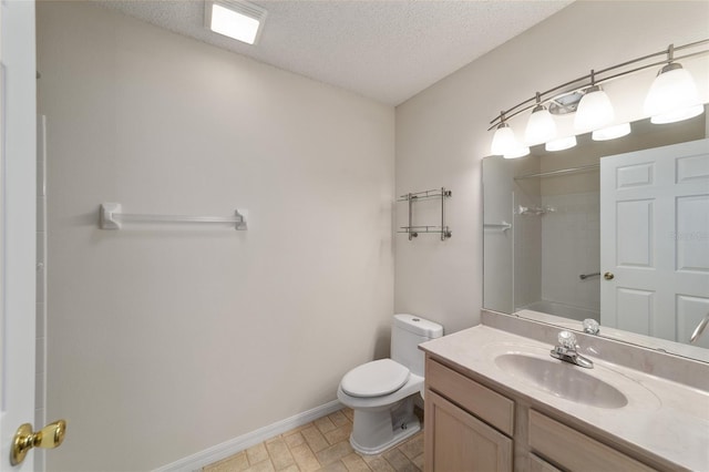 bathroom featuring tile flooring, oversized vanity, toilet, and a textured ceiling