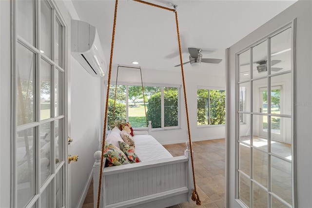 sunroom / solarium with a wall mounted AC, ceiling fan, and french doors