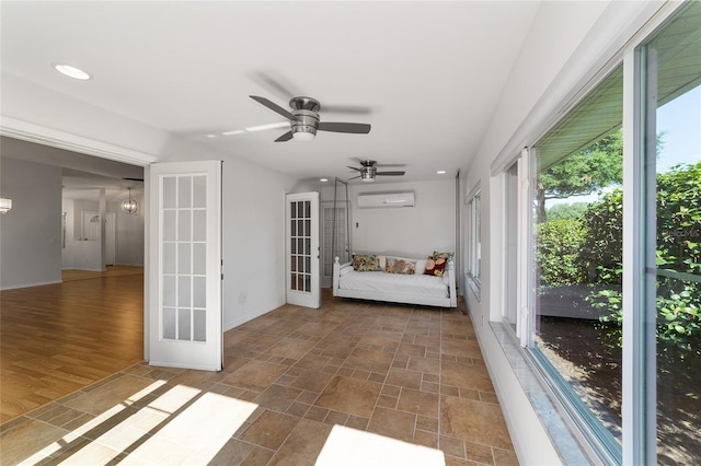 unfurnished sunroom with a wealth of natural light, ceiling fan, and a wall unit AC