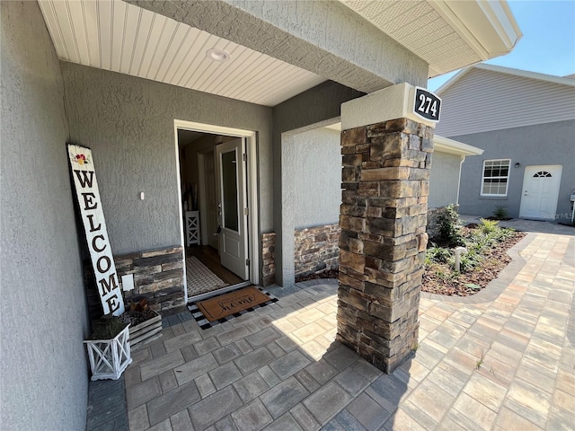 view of exterior entry featuring a patio area