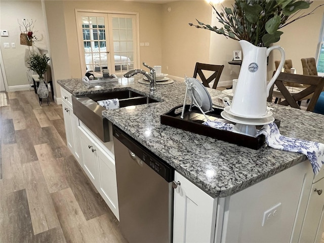 kitchen with white cabinets, stone countertops, french doors, and dishwasher