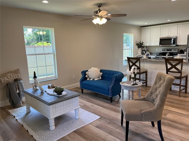 living room with ceiling fan and light hardwood / wood-style floors