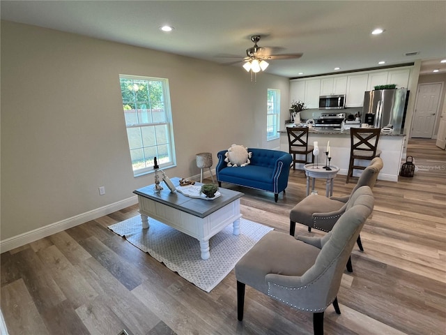 living room featuring ceiling fan and light hardwood / wood-style flooring