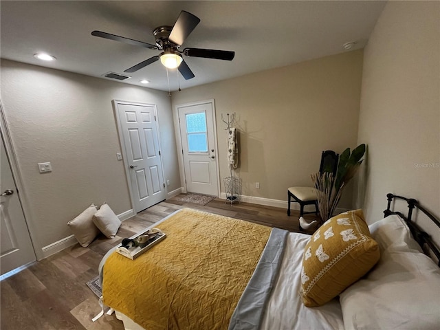 bedroom with dark hardwood / wood-style flooring and ceiling fan