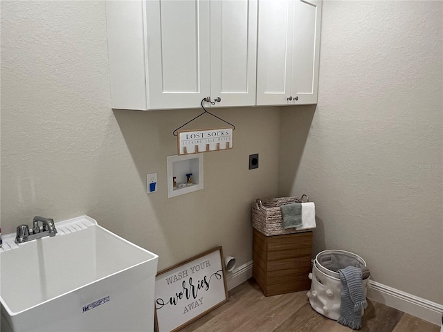 washroom featuring cabinets, hookup for an electric dryer, washer hookup, sink, and light hardwood / wood-style flooring