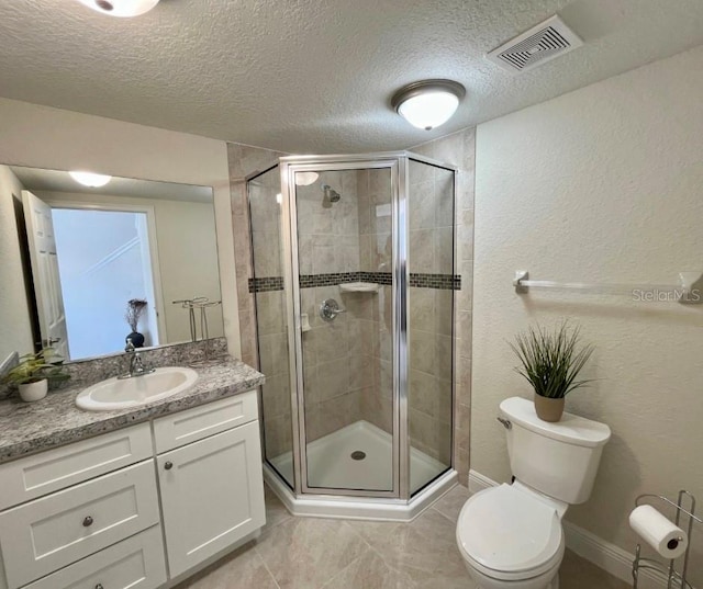 bathroom with a textured ceiling, vanity, a shower with shower door, and toilet