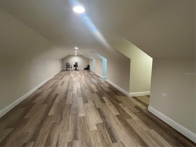 additional living space featuring lofted ceiling and hardwood / wood-style flooring