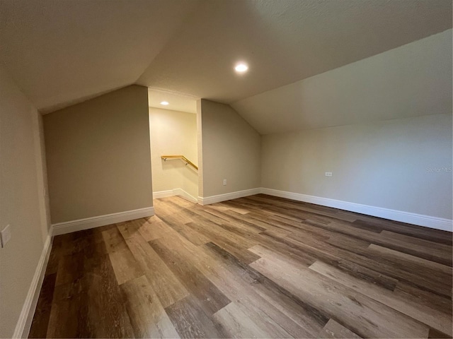 bonus room with lofted ceiling and light wood-type flooring