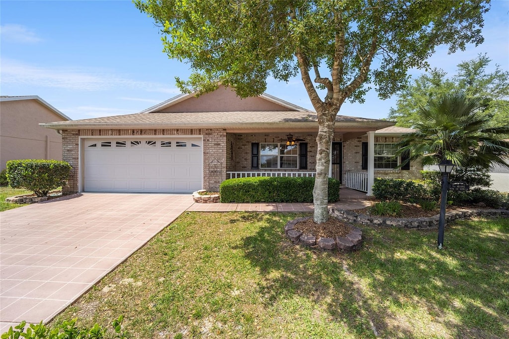 single story home featuring a front lawn, a porch, and a garage