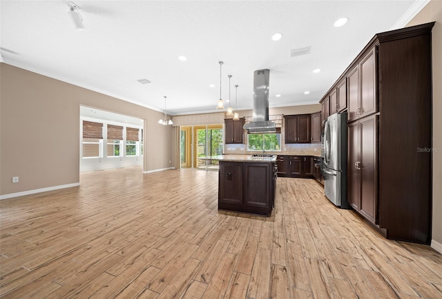 3396 NW 55th Ct, Ocala, FL 34482 - kitchen with island exhaust hood, freestanding refrigerator, open floor plan, light wood-style flooring, and dark brown cabinetry