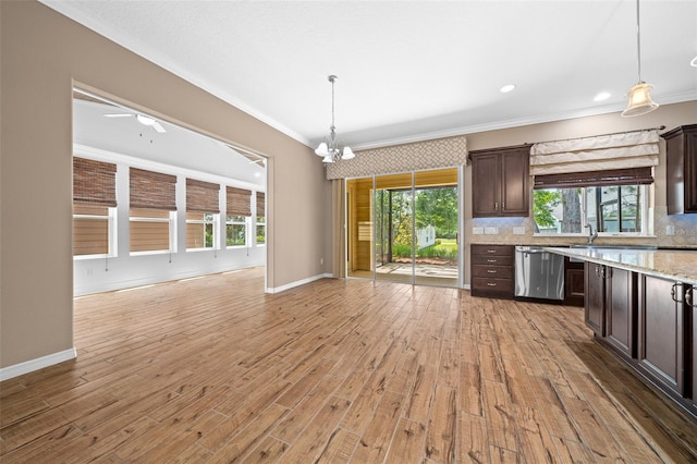 kitchen featuring dishwasher, plenty of natural light, dark brown cabinets, and light hardwood / wood-style flooring