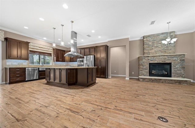 kitchen with light wood-type flooring, decorative light fixtures, dark brown cabinets, island exhaust hood, and stainless steel appliances