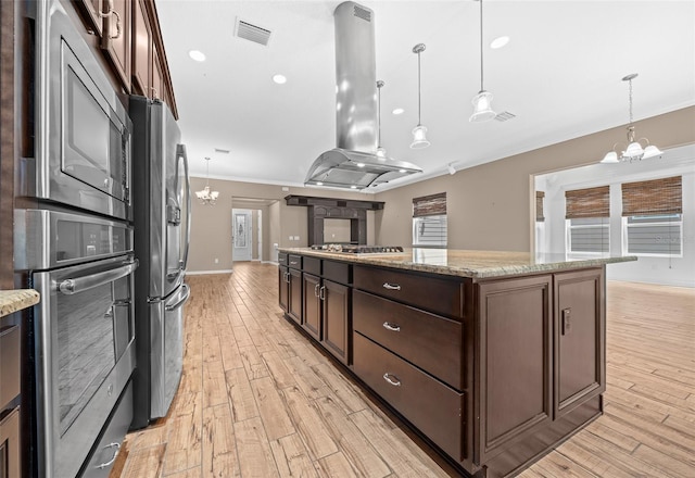 kitchen with stainless steel appliances, island exhaust hood, light hardwood / wood-style floors, decorative light fixtures, and dark brown cabinets