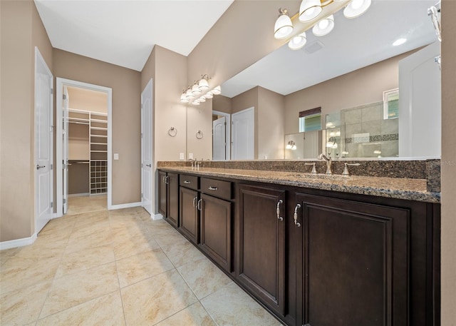 bathroom featuring tile patterned flooring, vanity, and walk in shower