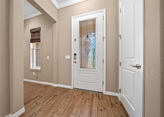 entryway with a wealth of natural light, light hardwood / wood-style flooring, and ornamental molding