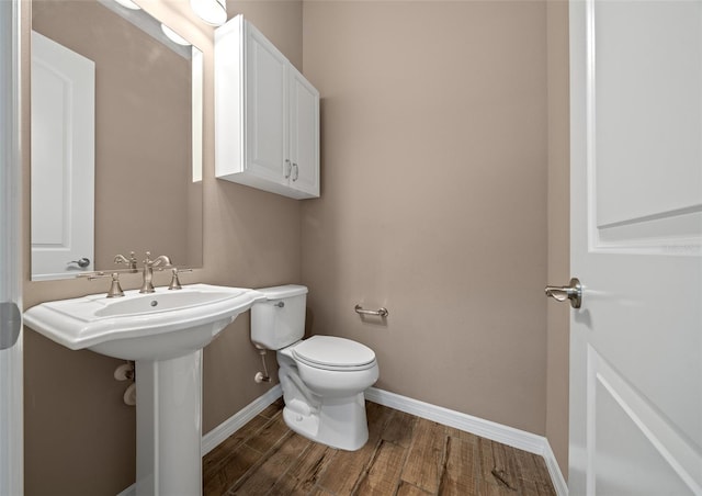 bathroom featuring wood-type flooring and toilet