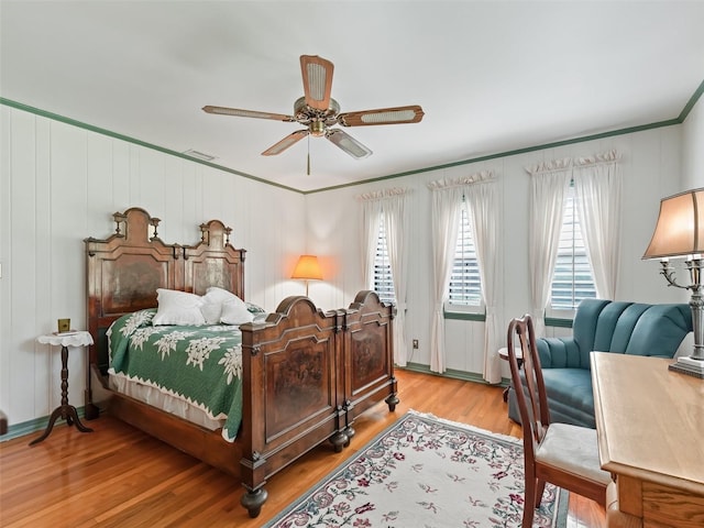 bedroom featuring hardwood / wood-style floors, ceiling fan, and ornamental molding