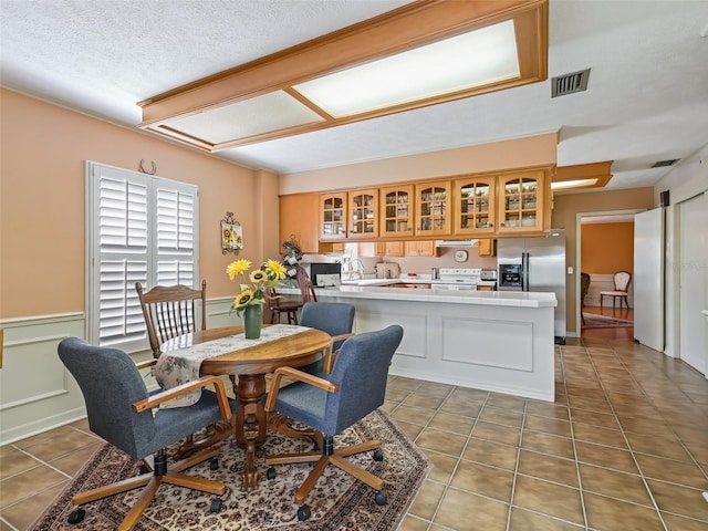 tiled dining room with a textured ceiling and sink