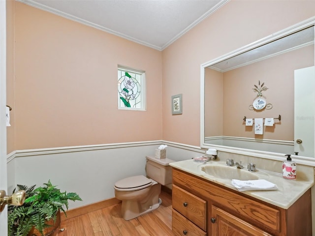 bathroom with vanity, toilet, hardwood / wood-style flooring, and crown molding