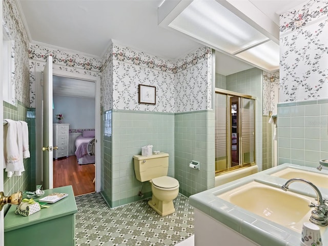 bathroom with tile flooring, vanity, toilet, and tile walls