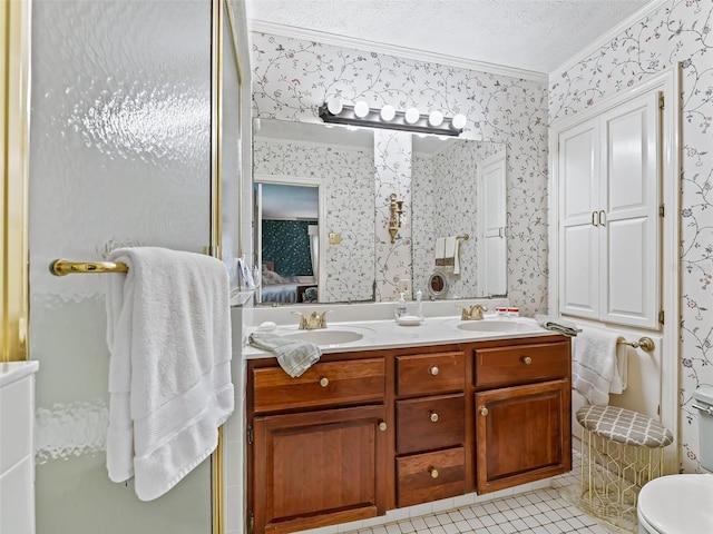 bathroom featuring dual bowl vanity, toilet, tile flooring, a textured ceiling, and ornamental molding