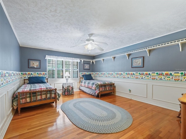 bedroom featuring light hardwood / wood-style floors, ceiling fan, and a textured ceiling