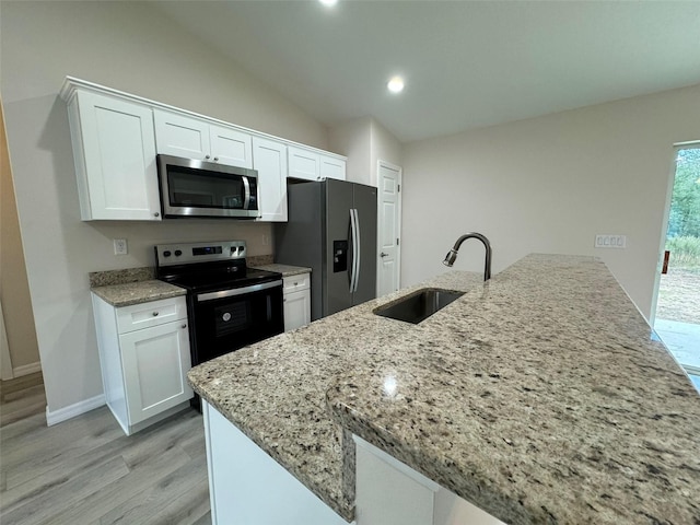 kitchen with sink, stainless steel appliances, light hardwood / wood-style flooring, vaulted ceiling, and white cabinets