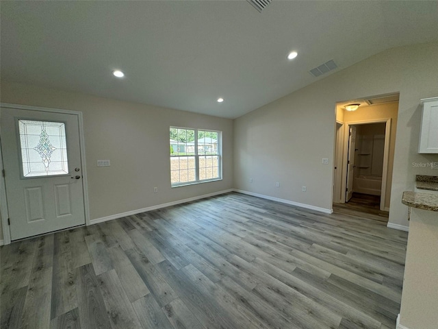 foyer entrance with light hardwood / wood-style flooring and lofted ceiling